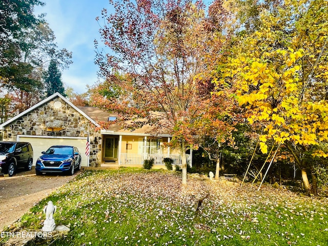 view of front facade featuring a garage, a front yard, and covered porch