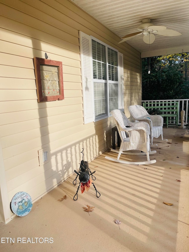 wooden terrace featuring covered porch and ceiling fan