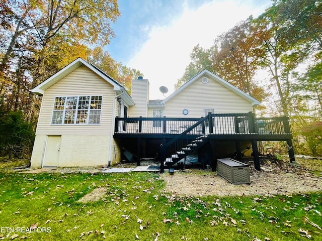 rear view of house featuring a yard and a wooden deck