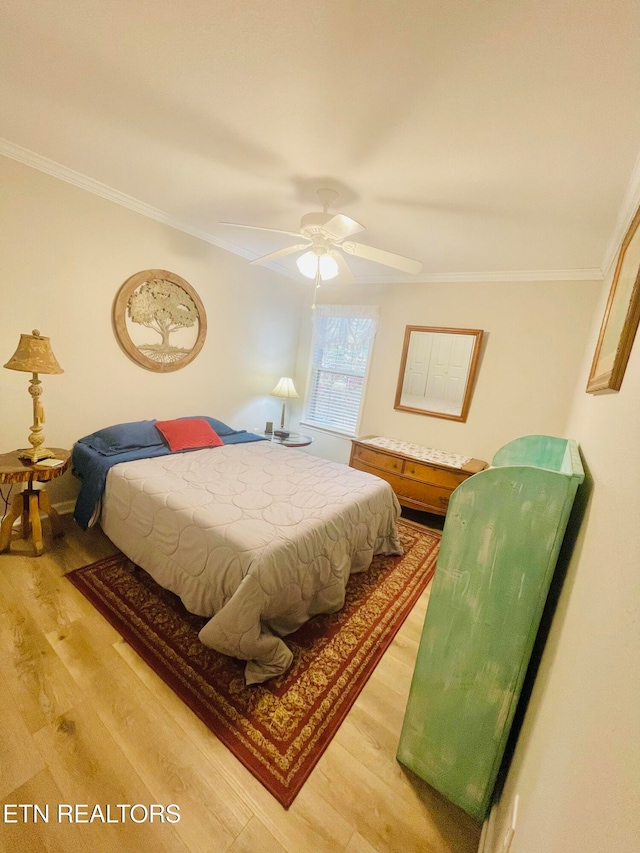 bedroom with ceiling fan, wood-type flooring, and crown molding