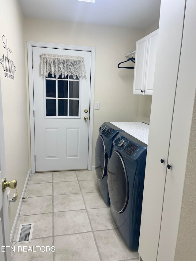 washroom featuring light tile patterned flooring, separate washer and dryer, and cabinets