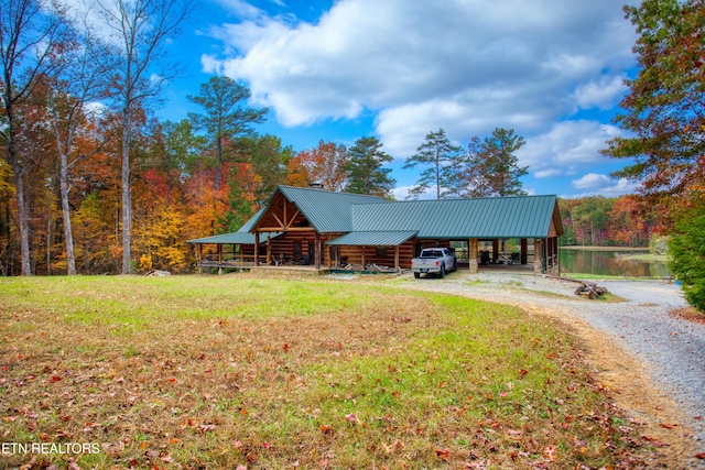 view of front facade with a water view, a carport, and a front lawn