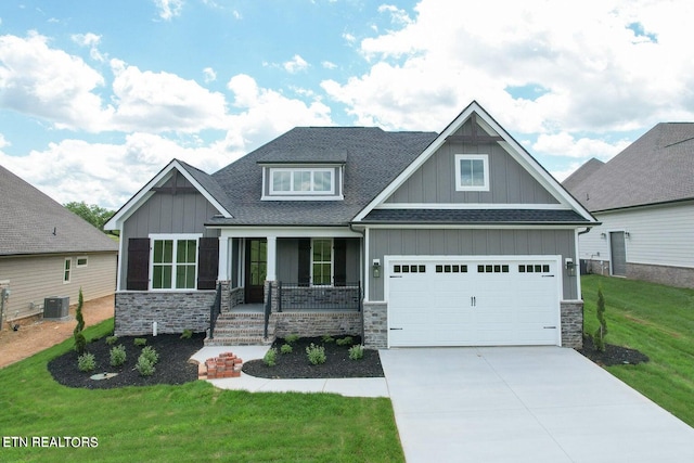 craftsman inspired home featuring central AC, covered porch, a garage, and a front lawn