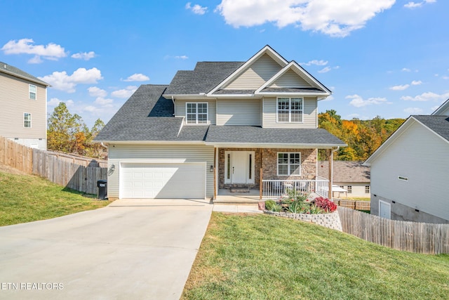 view of front of home featuring a front yard, covered porch, and a garage