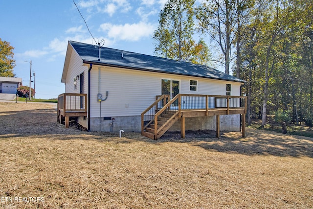 rear view of property featuring a yard and a deck