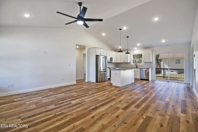 kitchen featuring appliances with stainless steel finishes, wood-type flooring, a kitchen island, hanging light fixtures, and white cabinets