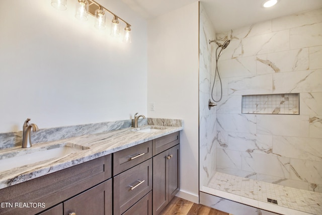 bathroom featuring vanity, hardwood / wood-style floors, and tiled shower