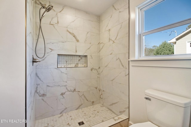 bathroom featuring toilet and a tile shower