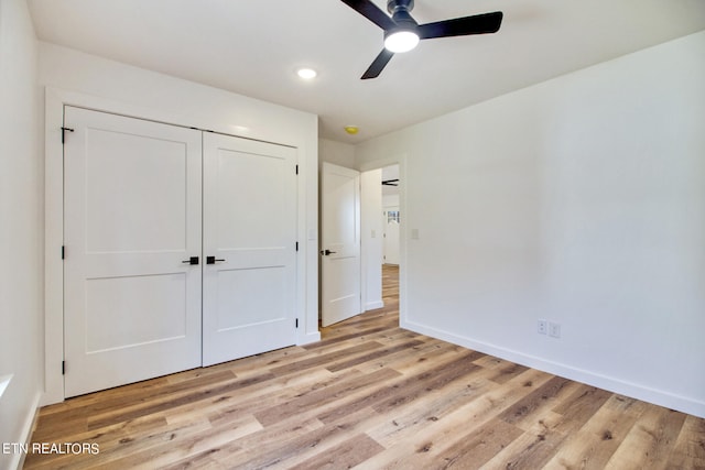 unfurnished bedroom featuring a closet, light wood-type flooring, and ceiling fan