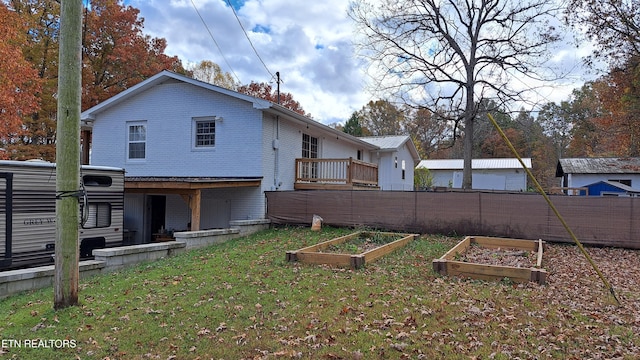 rear view of property with a wooden deck and a yard