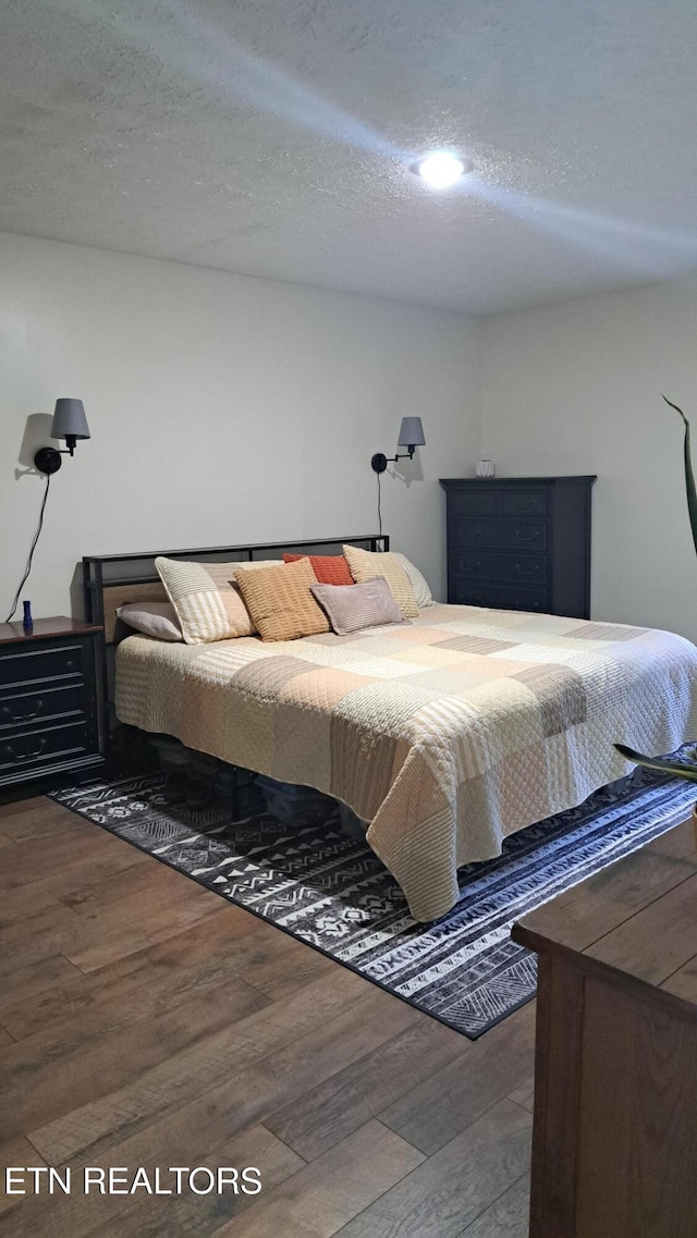 bedroom featuring wood-type flooring and a textured ceiling