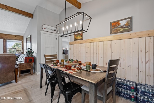 dining area with a chandelier, vaulted ceiling with beams, wood-type flooring, and wood walls