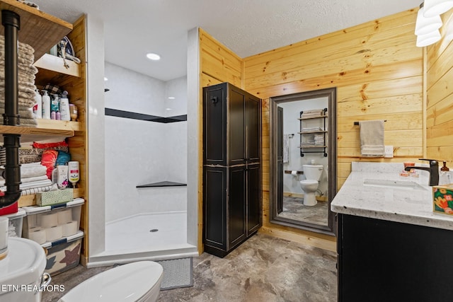 bathroom featuring a textured ceiling, a shower, toilet, wood walls, and vanity