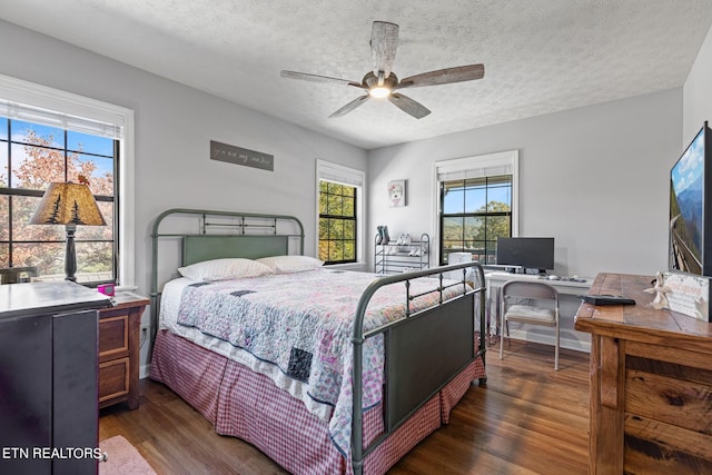 bedroom with ceiling fan, a textured ceiling, and dark hardwood / wood-style flooring