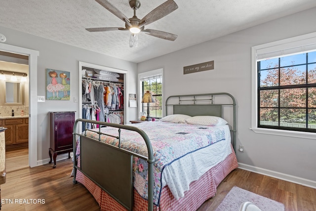 bedroom with a closet, ceiling fan, a textured ceiling, and dark hardwood / wood-style floors