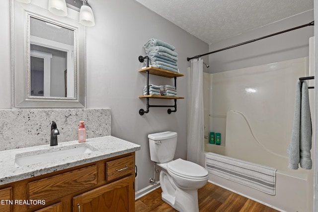 full bathroom featuring hardwood / wood-style floors, a textured ceiling, toilet, shower / bath combo, and vanity