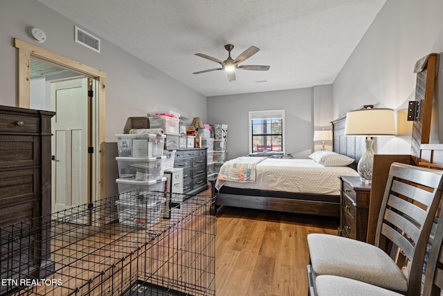 bedroom with light hardwood / wood-style floors, a textured ceiling, and ceiling fan