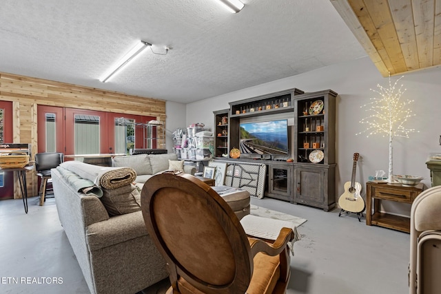 living room featuring a textured ceiling and wood walls