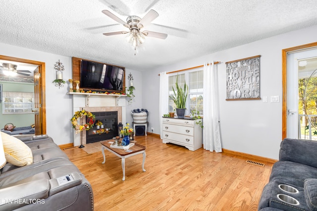 living room with a textured ceiling, light hardwood / wood-style flooring, and plenty of natural light