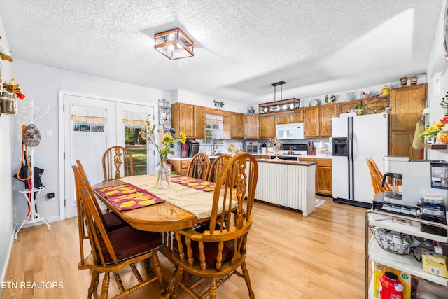 dining room featuring a textured ceiling and light wood-type flooring