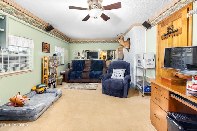 living room featuring ceiling fan, crown molding, a textured ceiling, and light colored carpet