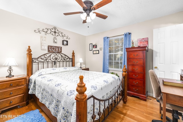 bedroom with light hardwood / wood-style flooring, a textured ceiling, and ceiling fan