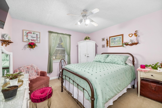 bedroom featuring light carpet, a textured ceiling, and ceiling fan