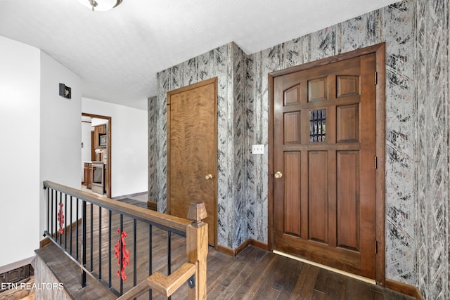 entrance foyer with dark hardwood / wood-style floors and a textured ceiling