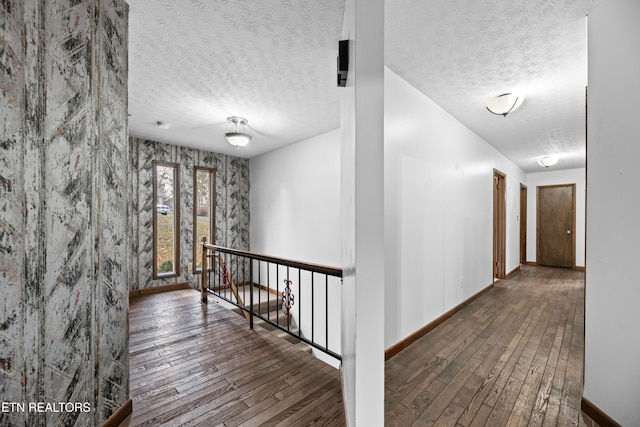 corridor featuring a textured ceiling and wood-type flooring