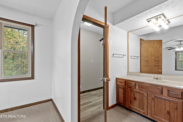 bathroom featuring vanity, ceiling fan, hardwood / wood-style flooring, and a wealth of natural light