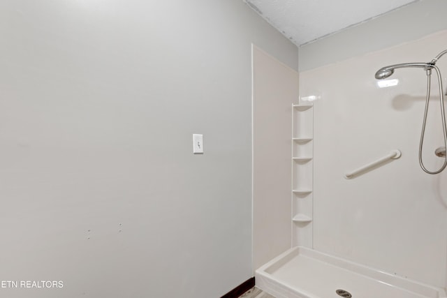 bathroom with walk in shower and a textured ceiling