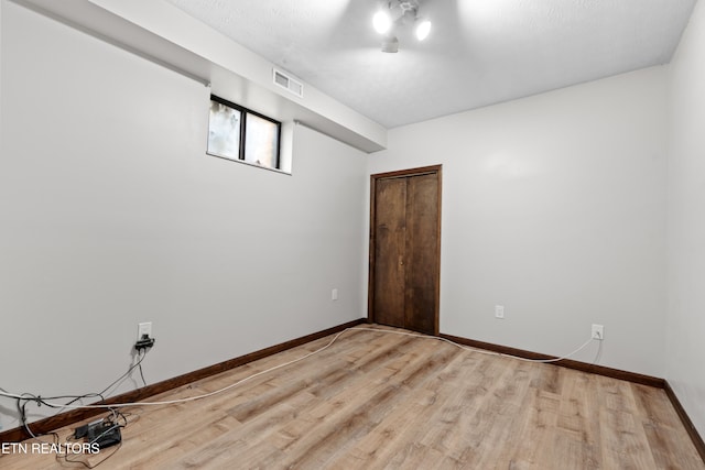 unfurnished room with wood-type flooring and a textured ceiling