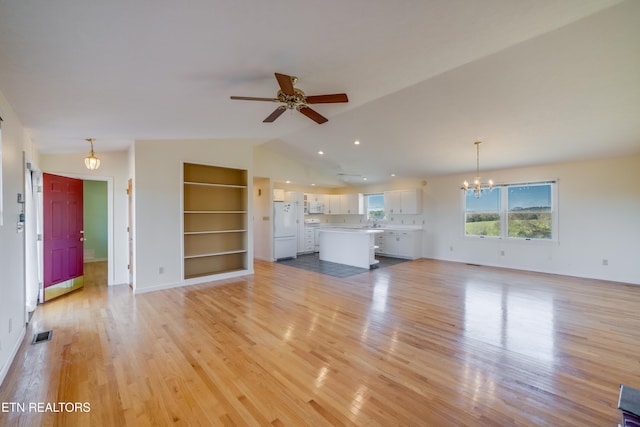 unfurnished living room with vaulted ceiling, built in features, light hardwood / wood-style flooring, and ceiling fan with notable chandelier