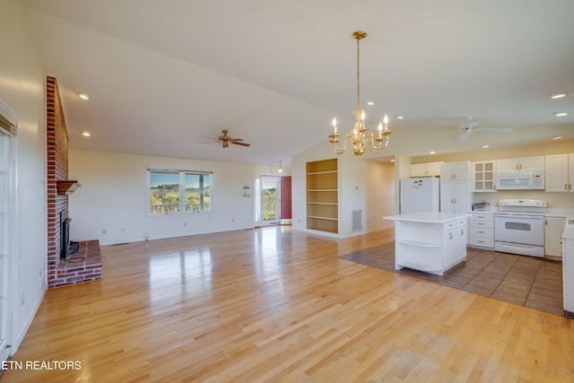 kitchen featuring white appliances, a center island, light wood-type flooring, and white cabinets