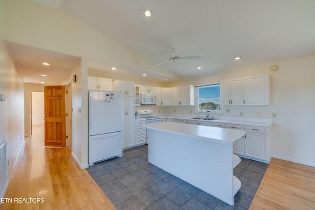 kitchen featuring white cabinets, dark hardwood / wood-style flooring, a kitchen island, sink, and white appliances