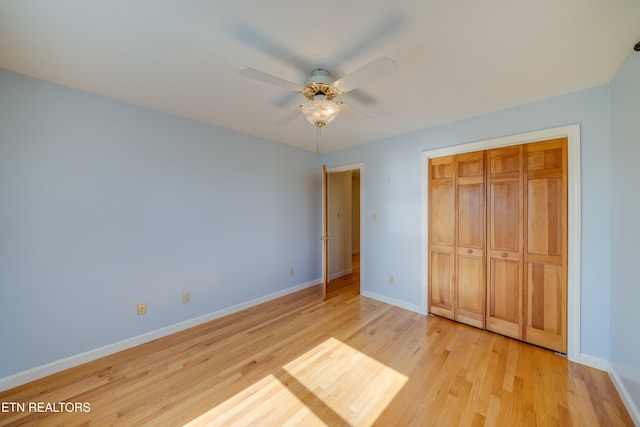 unfurnished bedroom with light hardwood / wood-style flooring, a closet, and ceiling fan