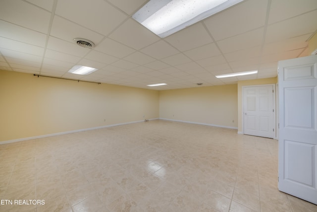 tiled empty room featuring a paneled ceiling