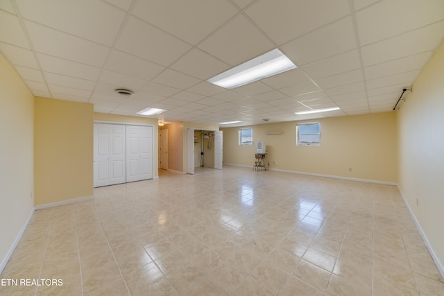 basement featuring light tile patterned floors and a drop ceiling