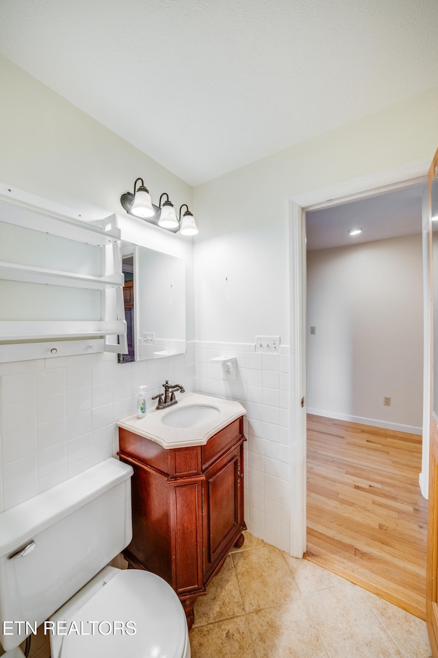 bathroom featuring tile walls, vanity, toilet, and tile patterned flooring