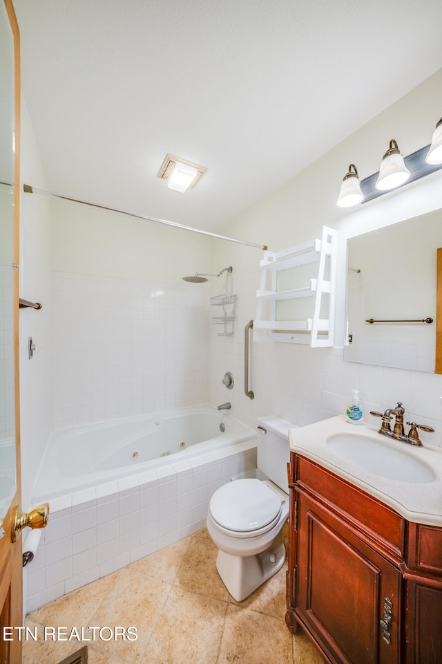 full bathroom with vanity, tiled shower / bath combo, toilet, and tile patterned floors