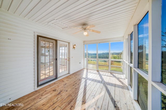 unfurnished sunroom featuring ceiling fan