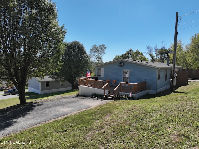 view of front of house with a deck and a front yard