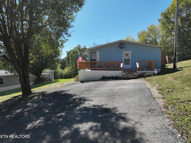 view of front facade with a front yard and a deck