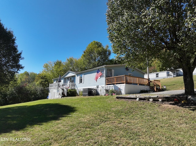 manufactured / mobile home featuring a front lawn and a deck