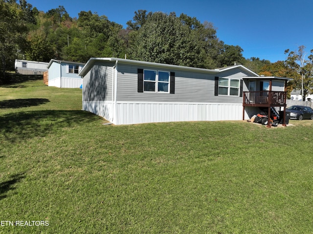 manufactured / mobile home with a front yard and a deck