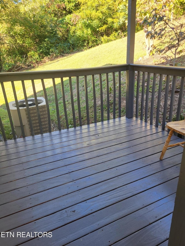 deck with a yard and central AC unit