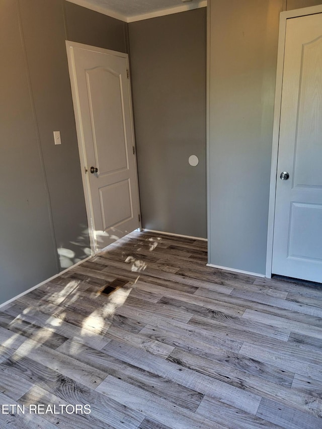 spare room featuring ornamental molding and hardwood / wood-style floors