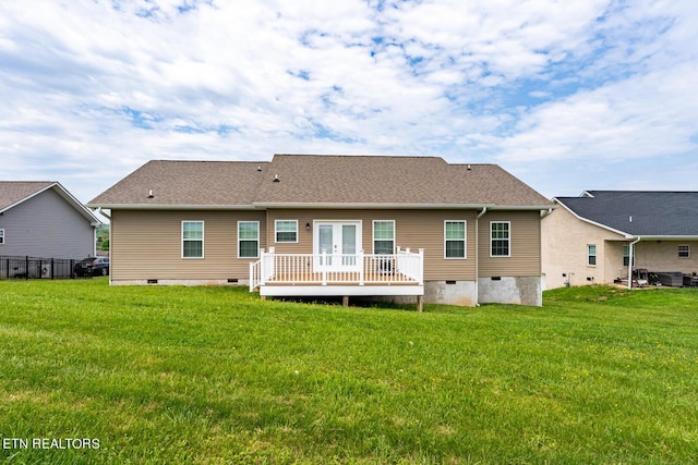 rear view of property featuring a wooden deck and a yard