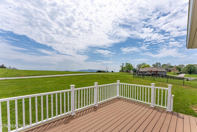 deck with a rural view and a lawn