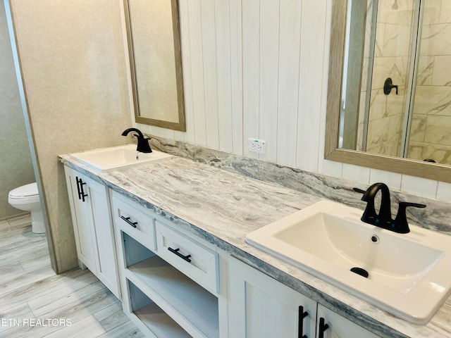 bathroom with vanity, toilet, wood-type flooring, and an enclosed shower